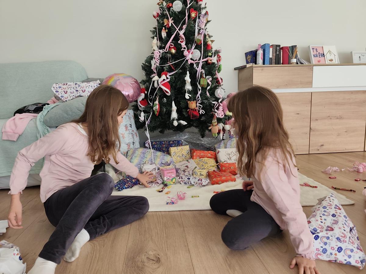 Vera y Noa, junto al árbol de Navidad antes de abrir los regalos el día de Reyes.