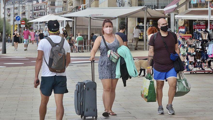 Una pareja camino del hotel por el Paseo de Silgar este verano.