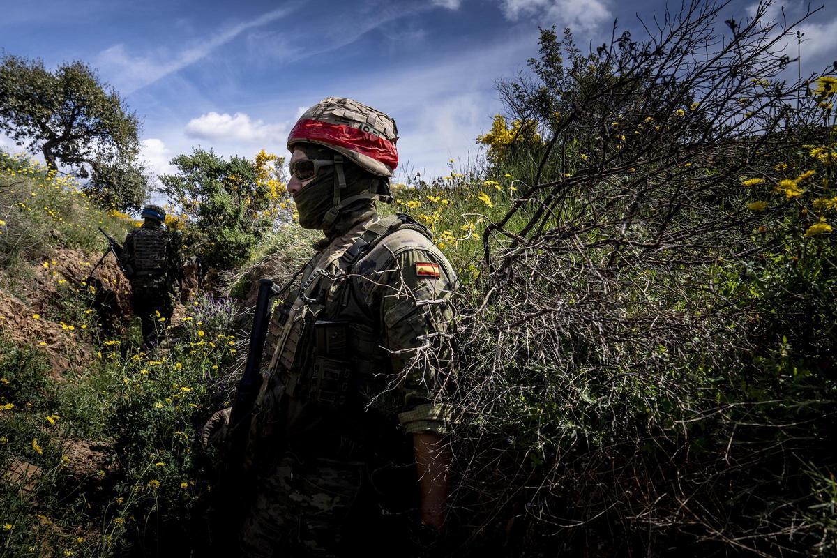 Un soldado español, con cinta roja en el casco, simula ser el 'soldado enemigo' durante el ejercicio.