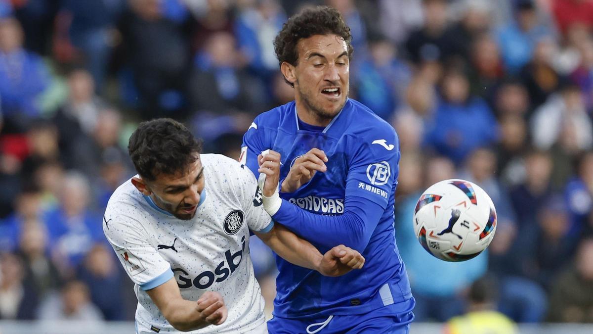 Iván Martín pelea por el balón con Luis Milla en el Getafe-Girona.