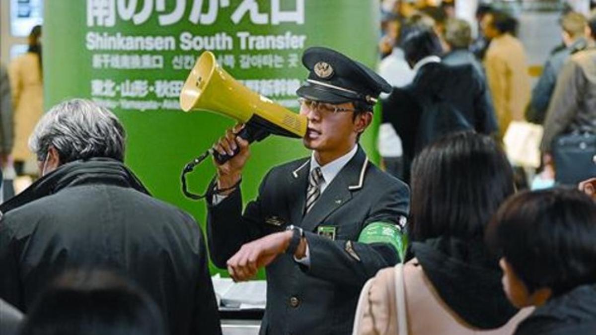 Un empleado ferroviario informa sobre la interrupción temporal del tren bala hacia el norte, ayer en Tokio.