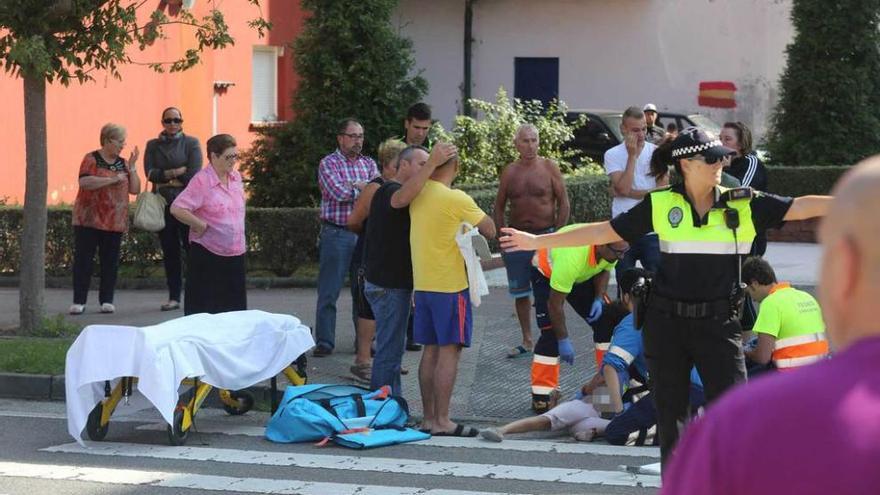 Los sanitarios atienden a la pequeña sobre la carretera.