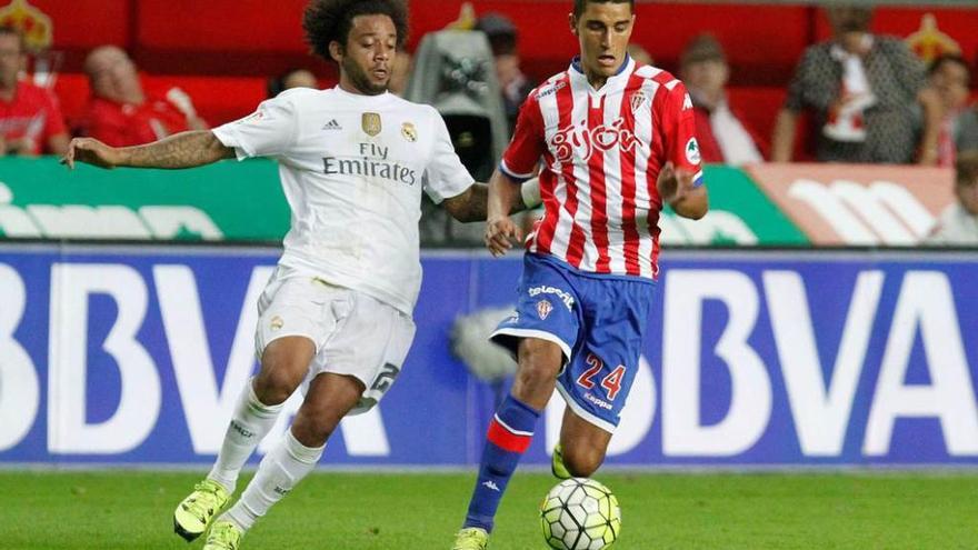 Rachid conduce un balón presionado por el madridista Marcelo.