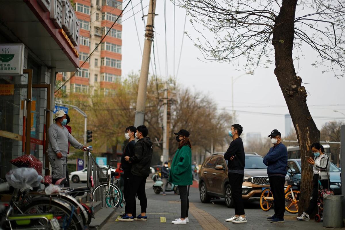 People practise social distancing as they queue to enter a supermarket, as the spread of coronavirus disease (COVID-19) continues in Beijing, China March 31, 2020. REUTERS/Thomas Peter