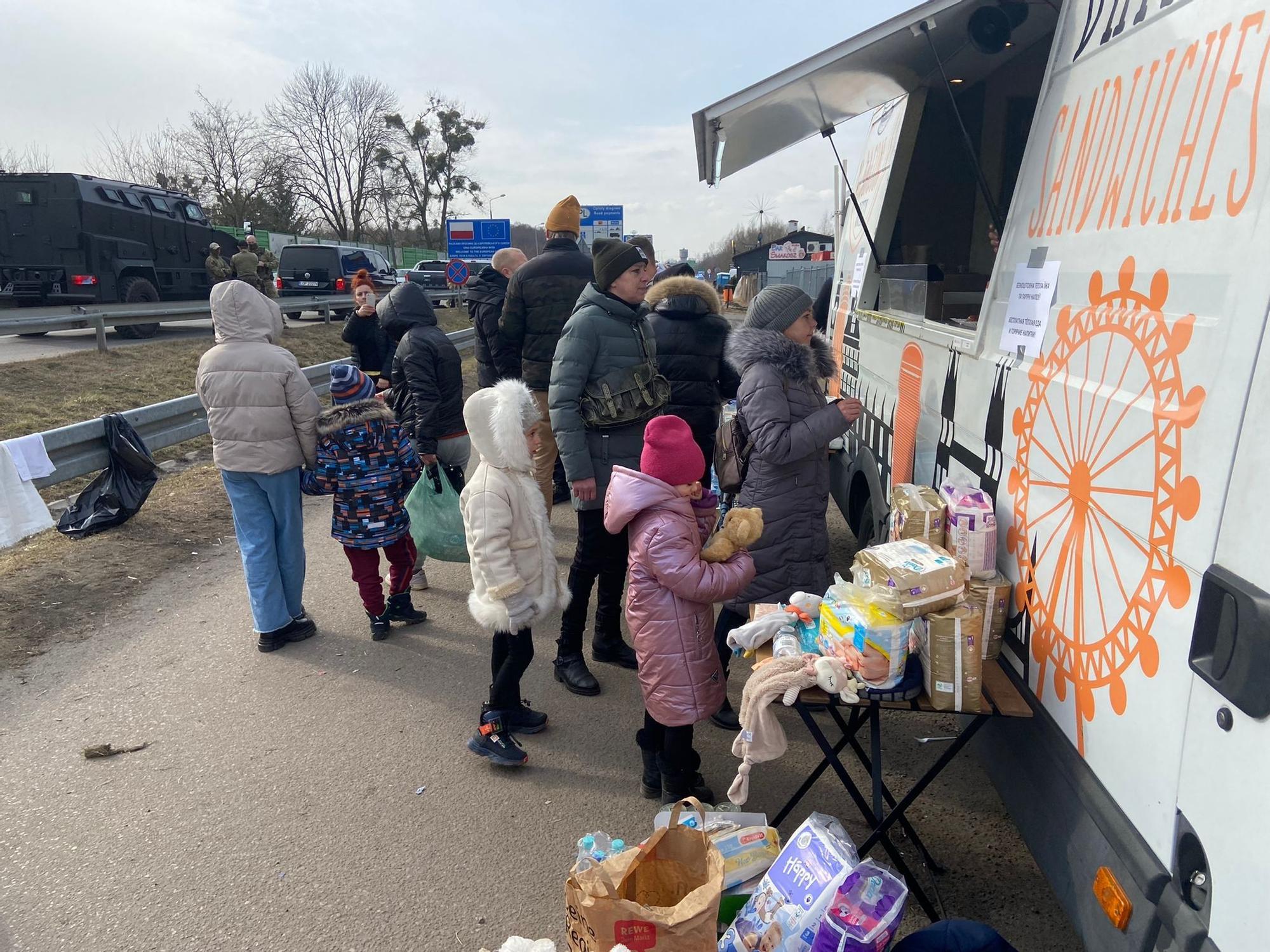 Regufiados aguardan su turno en un puesto de comida en Dorohusk (Polonia).