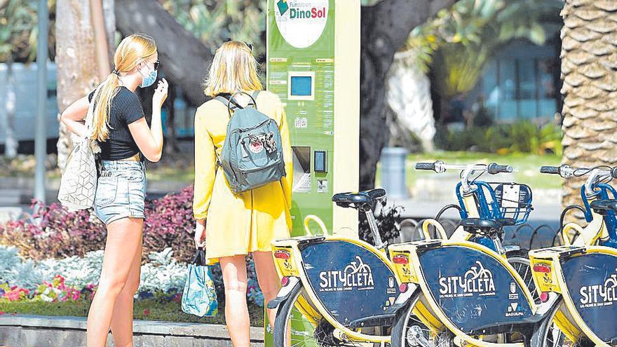 Dos turistas se interesan por el sistema de alquiler de bicicletas de Las Palmas de Gran Canaria.