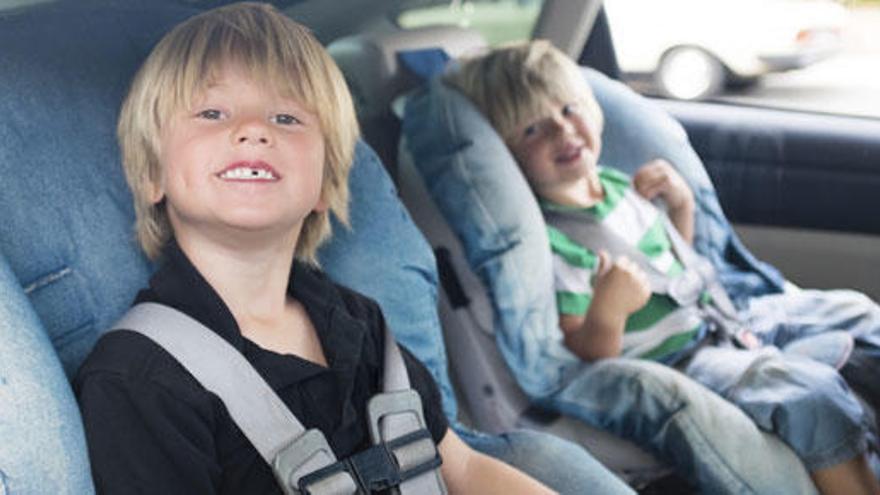 Dos niños, en la parte trasera de un coche.