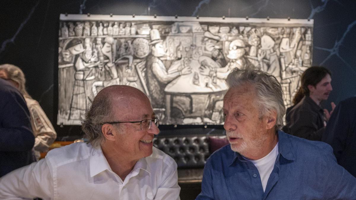 Javier Marsical junto a javier de las Muelas en una de las barras de la coctelería Dry Martini con la particular versión del ilustrador de Los jugadores de cartas colgada detrás en la pared, en la que Mariscal se rinde a Cézanne.