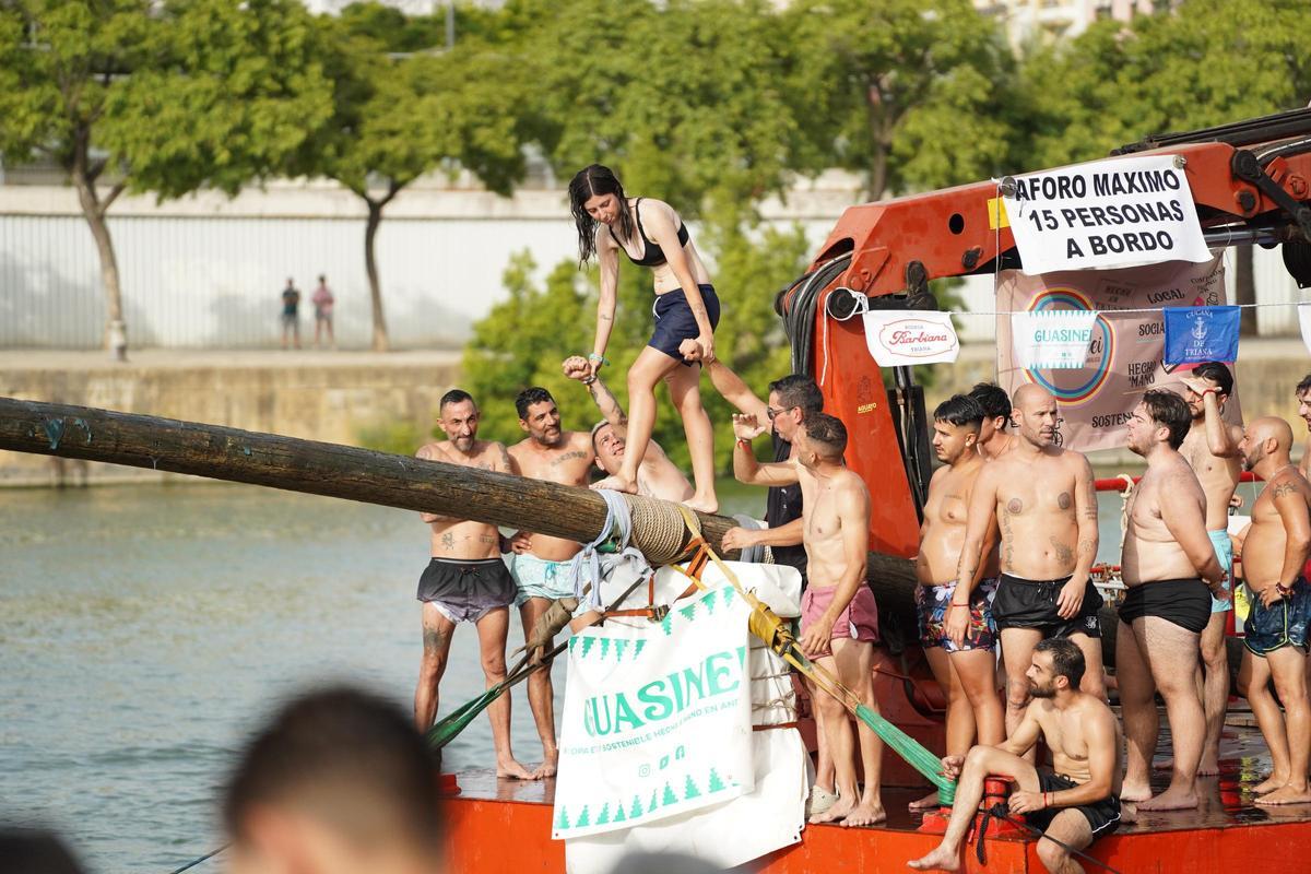 La 'cucaña', el juego centenario que regresa cada verano al río Guadalquivir por la Velá de Santa Ana en imágenes