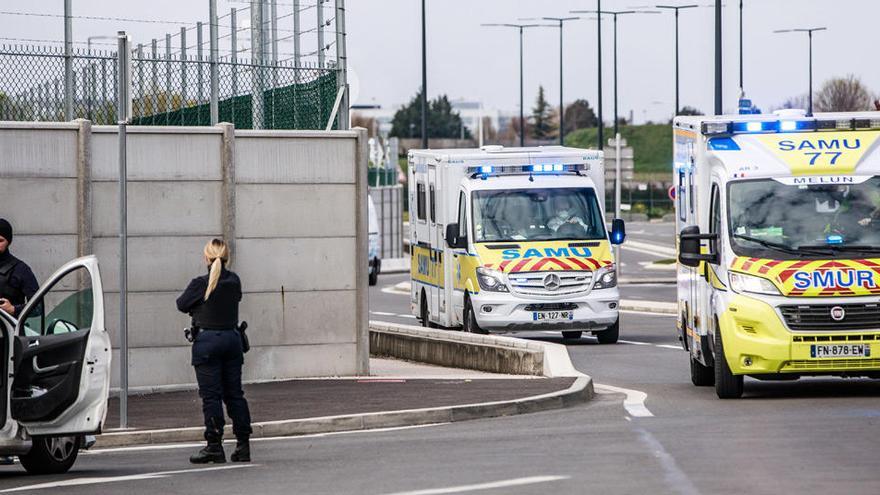 Varios agentes de la policía francesa vigilan una ambulancia.