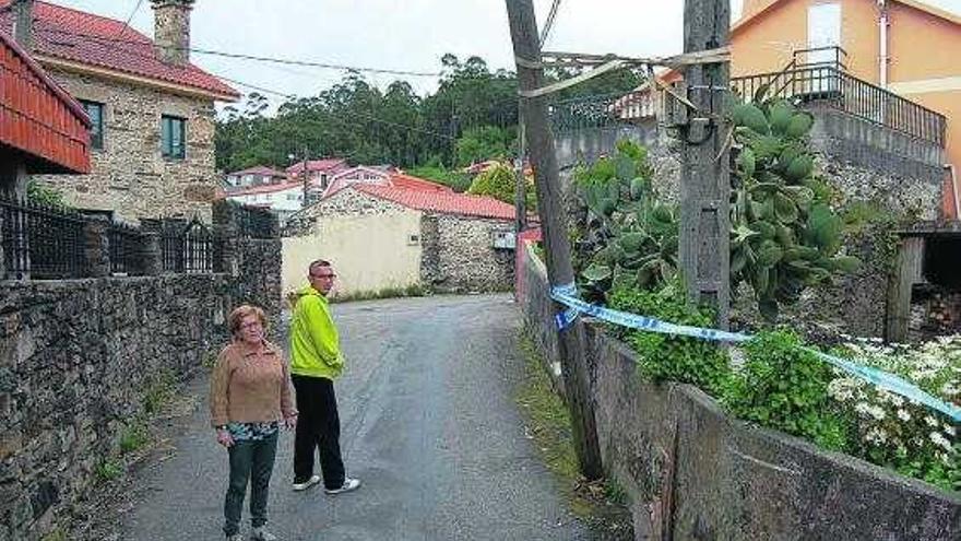 El poste de madera, roto en la base y sujeto por una correa, en el Camiño Xestal, en Trasmañó.  // Faro