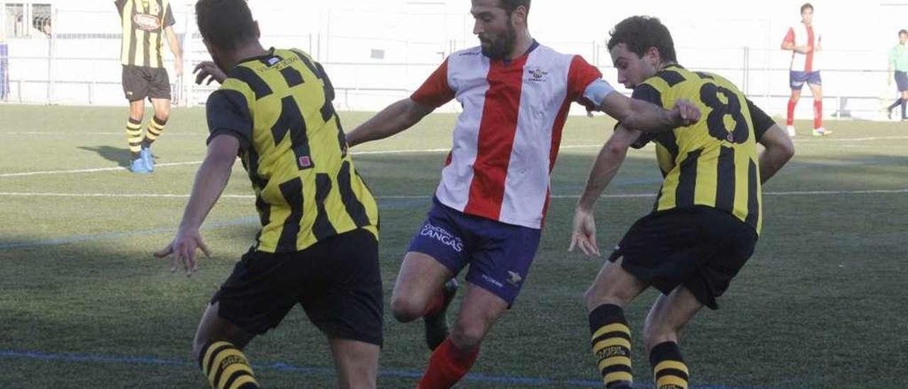 Andrés controla el balón entre dos contrarios en el partido de la primera vuelta. // Santos Álvarez