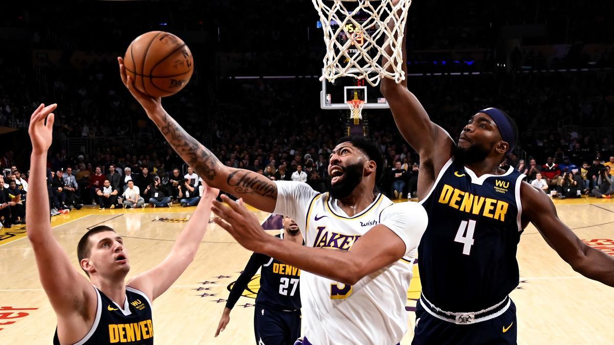 Archivo - Anthony Davis pelea con Nikola Jokic por un balón.