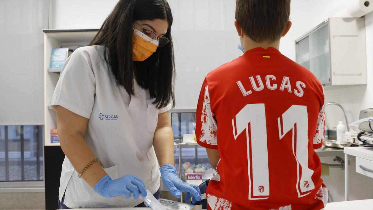 Una enfermera pon e la vacuna del papiloma a un niño en Navia