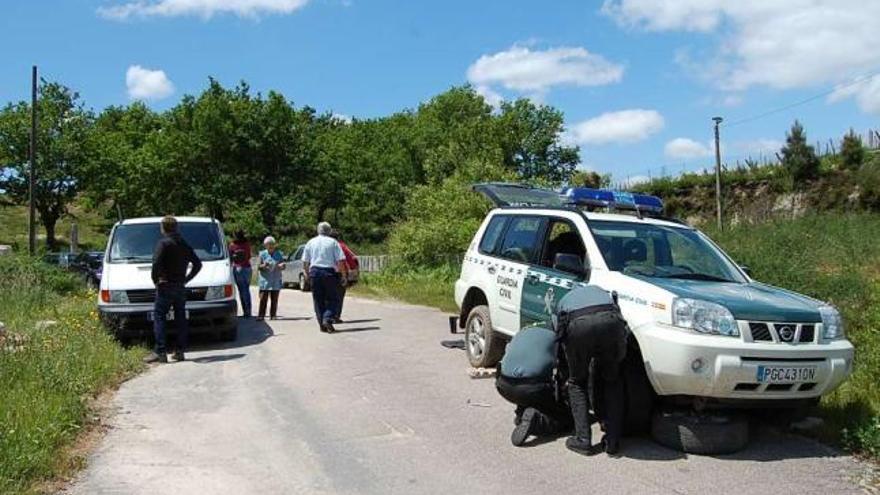 Una patrulla de la Guardia Civil repara una rueda de su coche tras la búsqueda, ayer, en la zona de Candán.