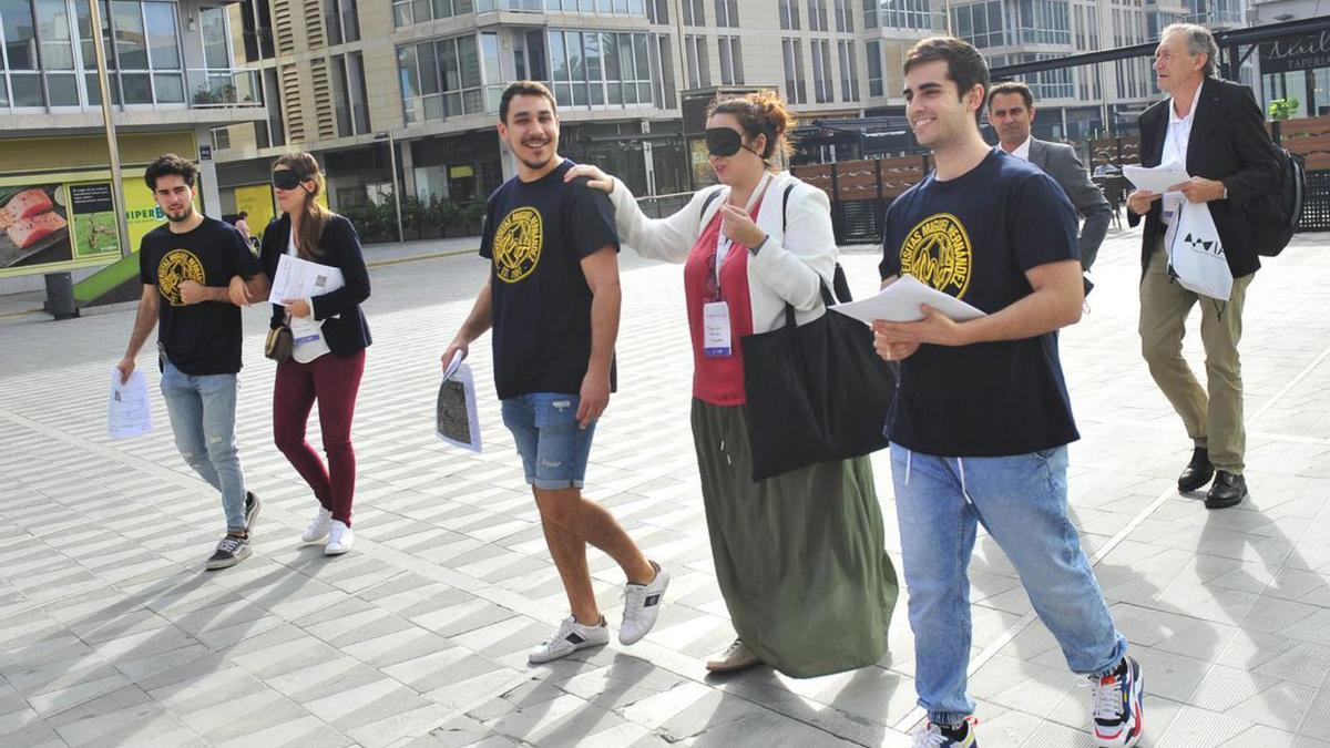 Una de las participantes con los ojos vendados es guiada por la ciudad. | MATÍAS SEGARRA