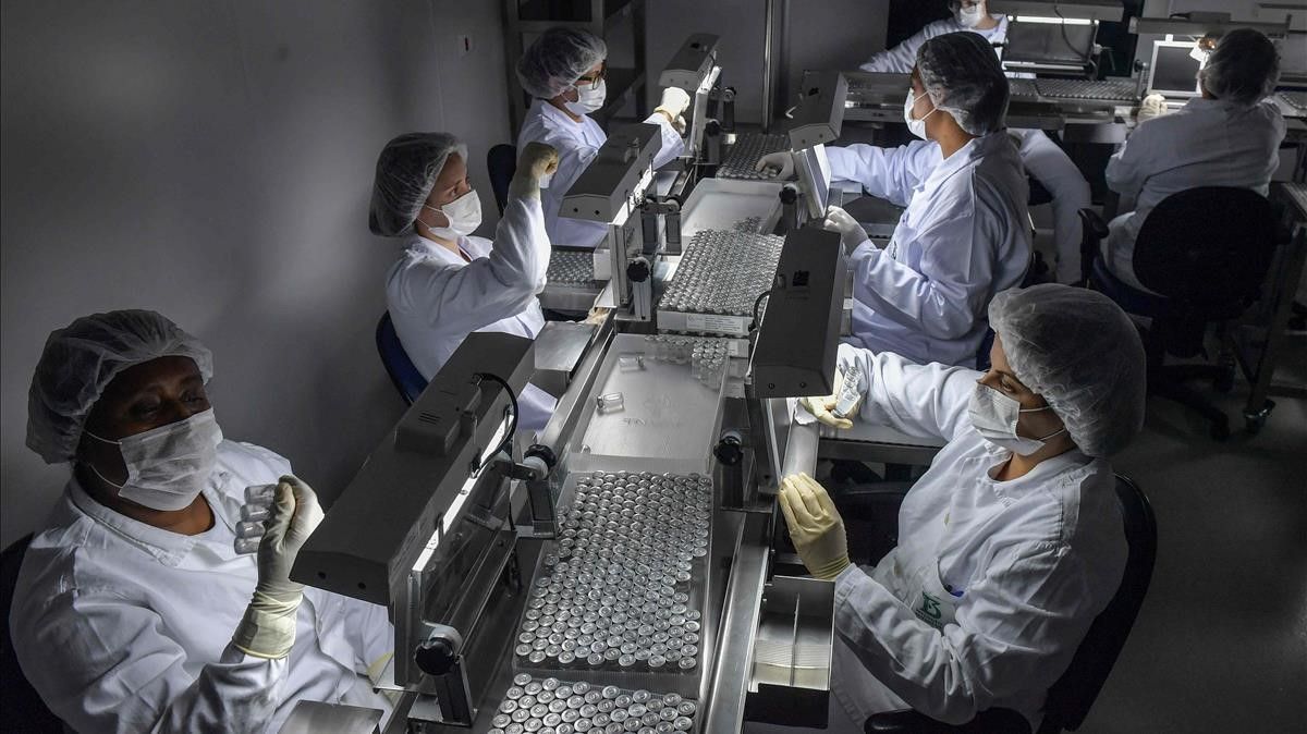 Employees work on the production line of CoronaVac  Sinovac Biotech s vaccine against COVID-19 coronavirus at the Butantan biomedical production center  in Sao Paulo  Brazil  on January 14  2021  - Sao Paulo state is due to begin immunizing its 12 million citizens from January 25  Beijing has already sent 10 7 million Coronavac doses and the supplies needed to make another 40 million doses  The health ministry  though  has yet to divulge when it will launch a nationwide immunization program  (Photo by NELSON ALMEIDA   AFP)