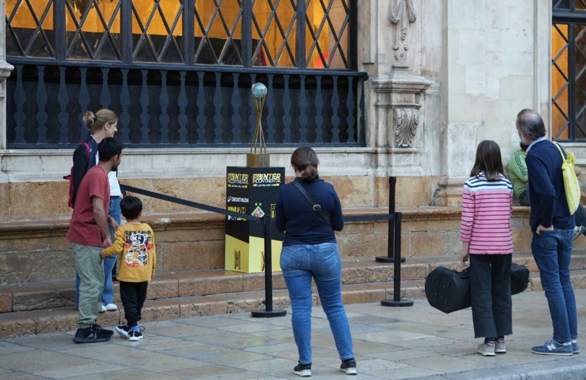 Unos curiosos observan la Copa Intercontinental instalado en Cort.