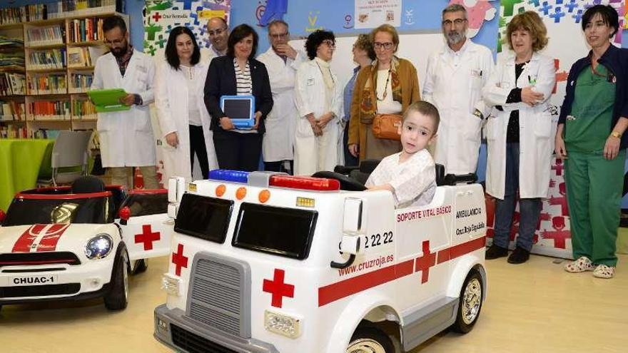 Un paciente en uno de los dos vehículos donados junto a personal del Materno y Cruz Roja, ayer.
