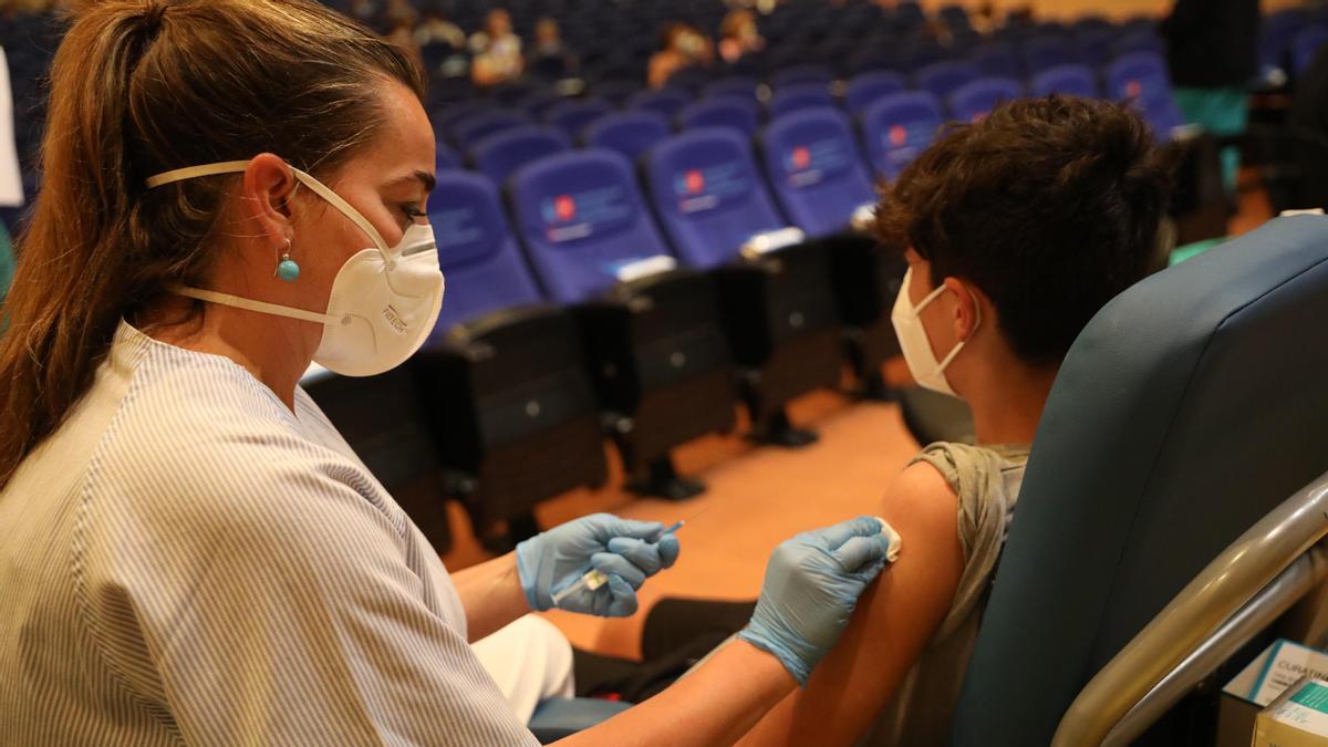 Una sanitaria vacunando a un menor contra el coronavirus.
