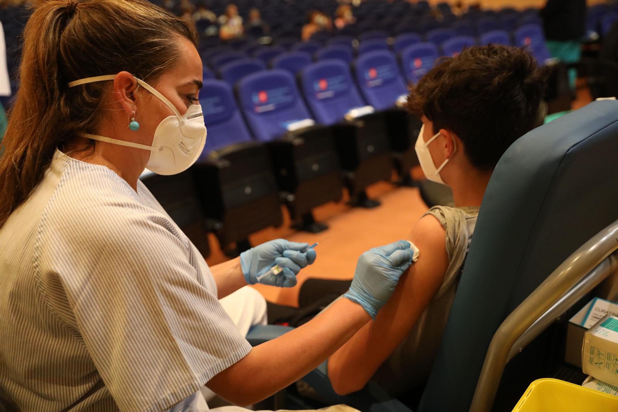 Una sanitaria vacunando a un menor contra el coronavirus.