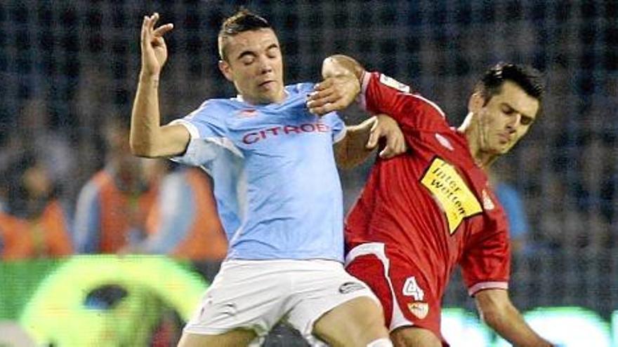 El delantero del Celta de Vigo Iago Aspas (i) pugna un balón con el bosnio Emir Spahic, del Sevilla CF.