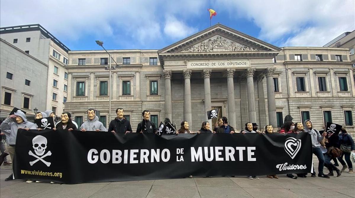 Manifestantes con mascaras de Dali se concentran con pancartas con el simbolo de la muerte frente al Congreso de los Diputados  en Madrid (Espana)  a 17 de diciembre de 2020  La accion forma parte de la campana Vividores  impulsada por la Asociacion Catolica de Propagandistas (ACdP)  contra la ley de la Eutanasia que hoy se aprueba en la Camara Baja   17 DICIEMBRE 2020  Eduardo Parra   Europa Press  17 12 2020