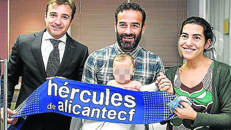 Paco Peña, primer capitán, y el presidente del Hércules Carlos Parodi posan con uno de los lactantes ingresados, y su madre, en Sant Joan