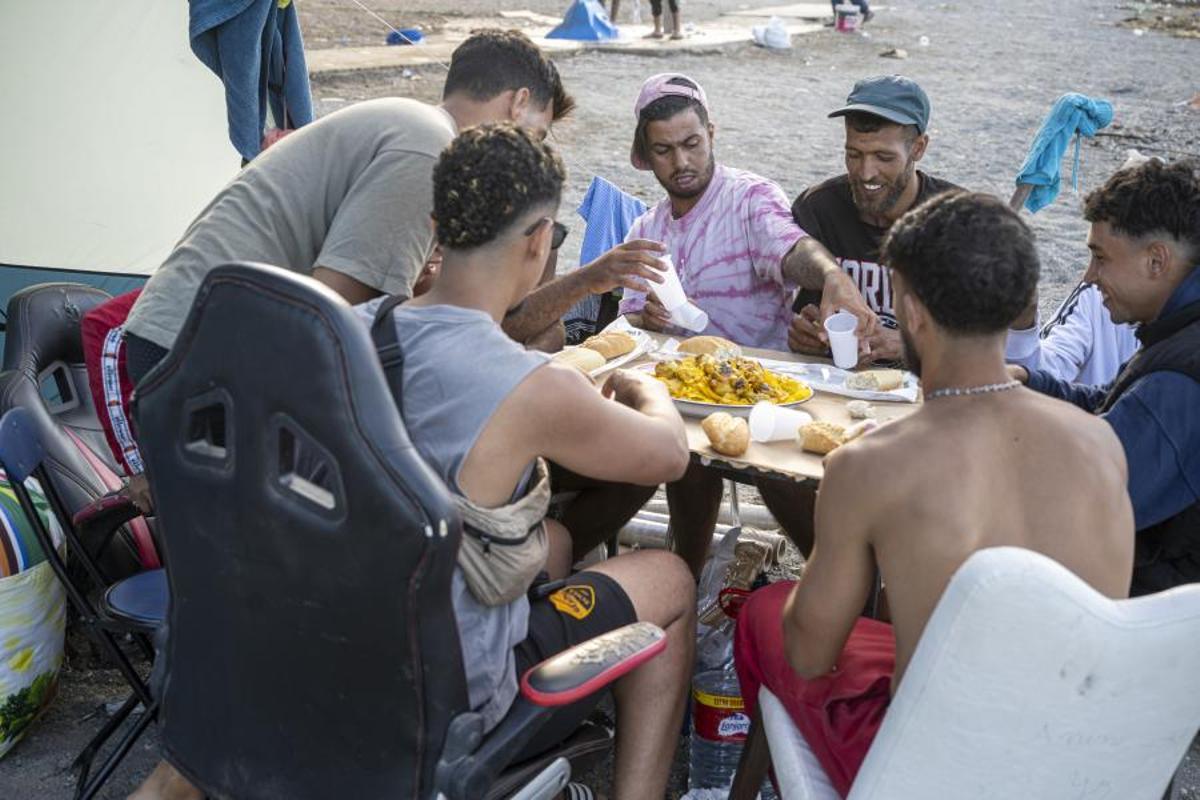 Un grupo de migrantes comparte alimentos en la playa ceutí de El Trampolín. Marcos Moreno 242940279
