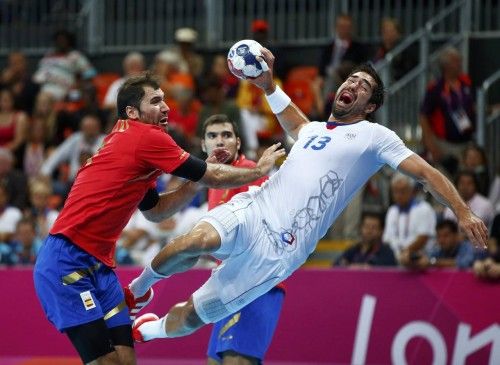 Spain's Joan Canellas Reixach pushes France's Nikola Karabatic as he attempts to score in their men's handball quarterfinals match at the Basketball Arena in London