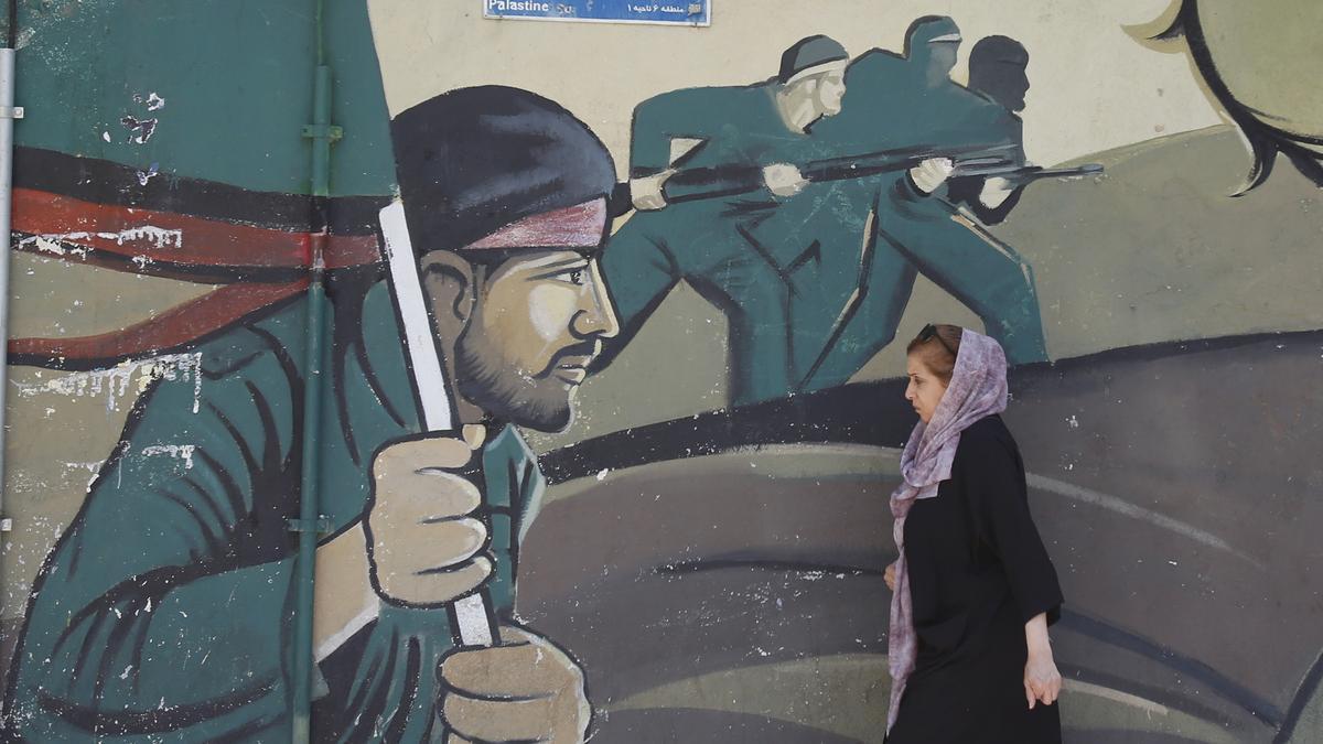 Teherán, Irán 14/04/2024.- Una mujer iraní camina junto a una pintura de la Guardia Revolucionaria Iraní (IRGC).