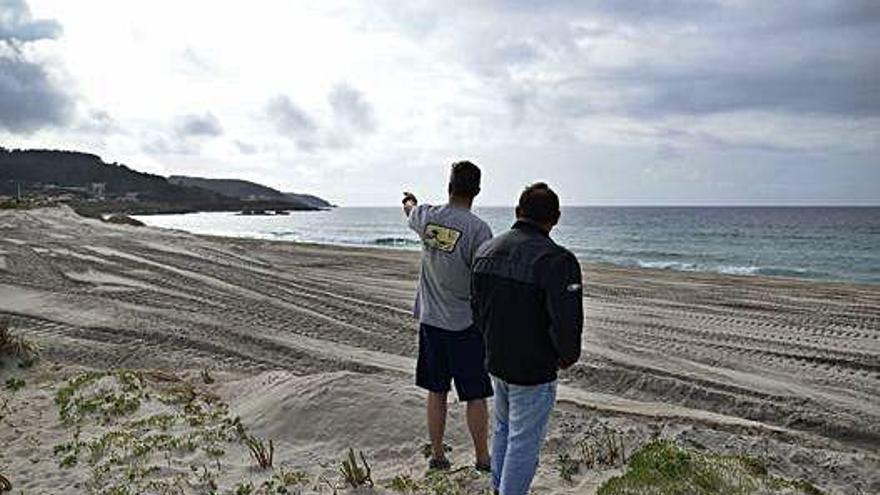 Dos personas en la playa de Barrañán, en Arteixo.