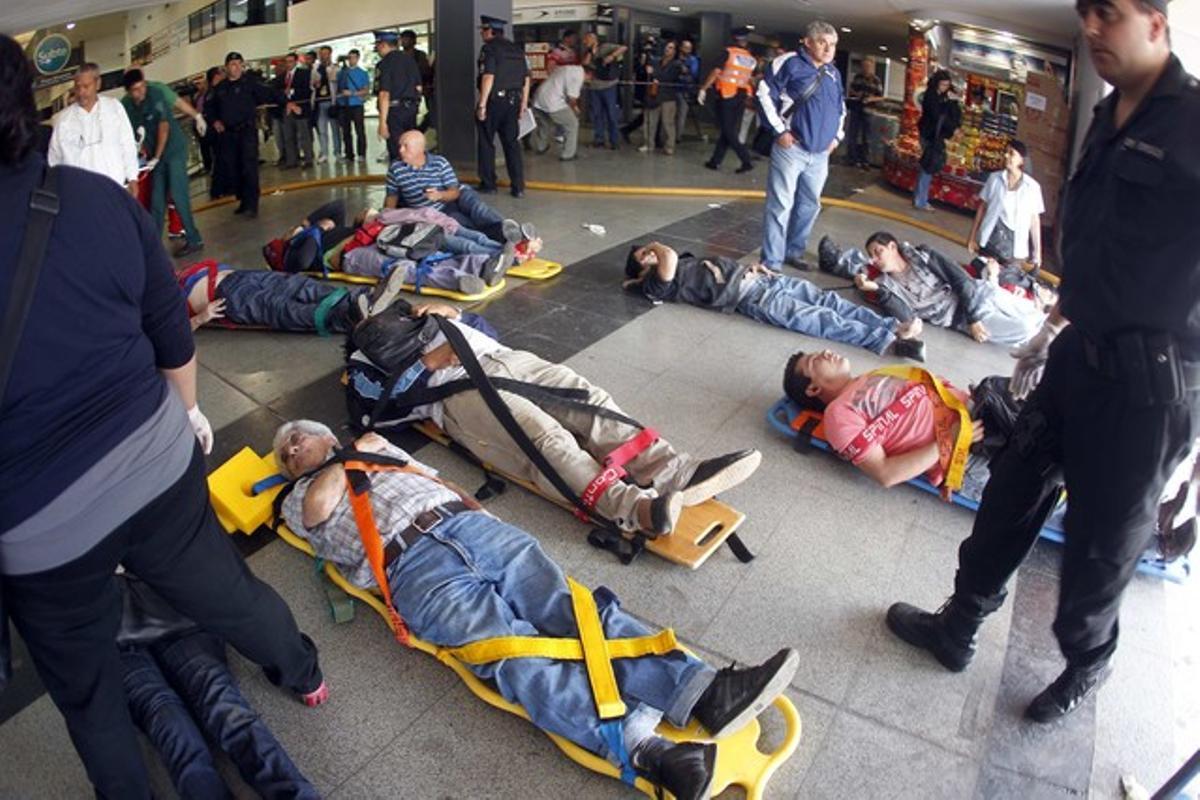 Un grup de ferits és atès després de l’impacte del comboi contra una de les andanes de l’estació terminal d’Once, al cor de la capital Argentina. Un grup de ferits és atès després de l’impacte del comboi contra una de les andanes de l’estació terminal d’Once, al cor de la capital Argentina.