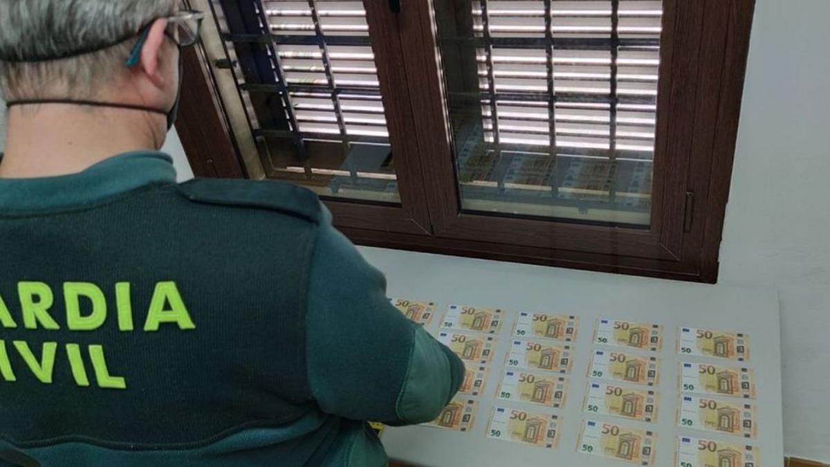 Un guardia civil examina los billetes intervenidos en Mallorca.