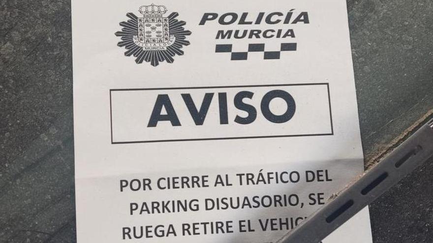 Aviso en el que el Ayuntamiento de Murcia anuncia la prohibición de estacionar en el aparcamiento ubicado junto al edificio de la antigua Oficina de Extranjería y bajo la autovía, en Barriomar
