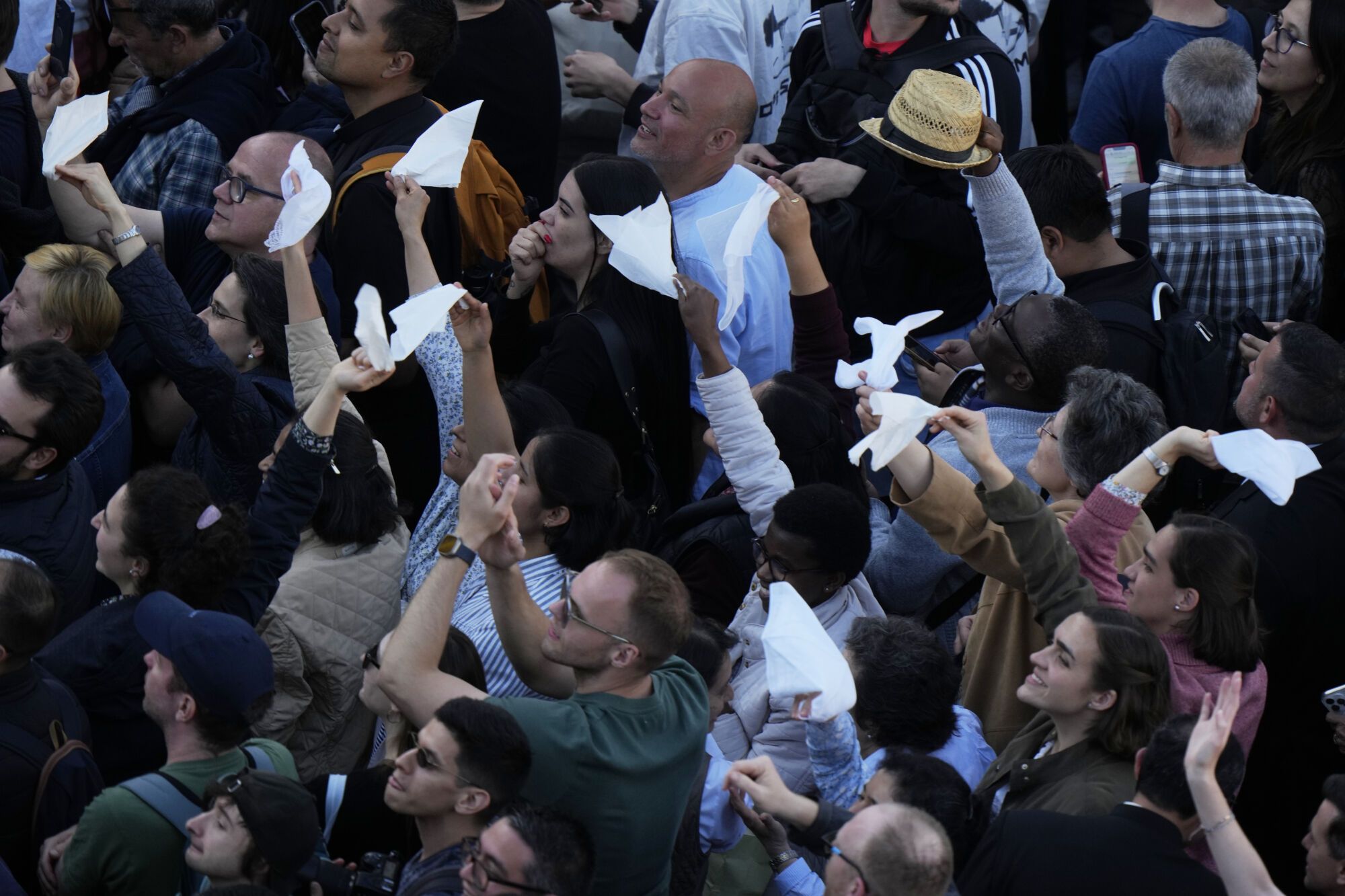 People react as white smoke billows from the chimney of the Sistine Chapel where 133 cardinals are gathering on the second day of the conclave to elect a successor to late Pope Francis, at the Vatican, Thursday, May 8, 2025. (AP Photo/Luca Bruno)