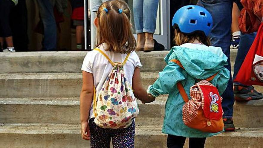 Dues nenes entrant en una escola a Barcelona, en una imatge d&#039;arxiu.