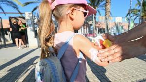 Niños protegidos del sol con crema solar.