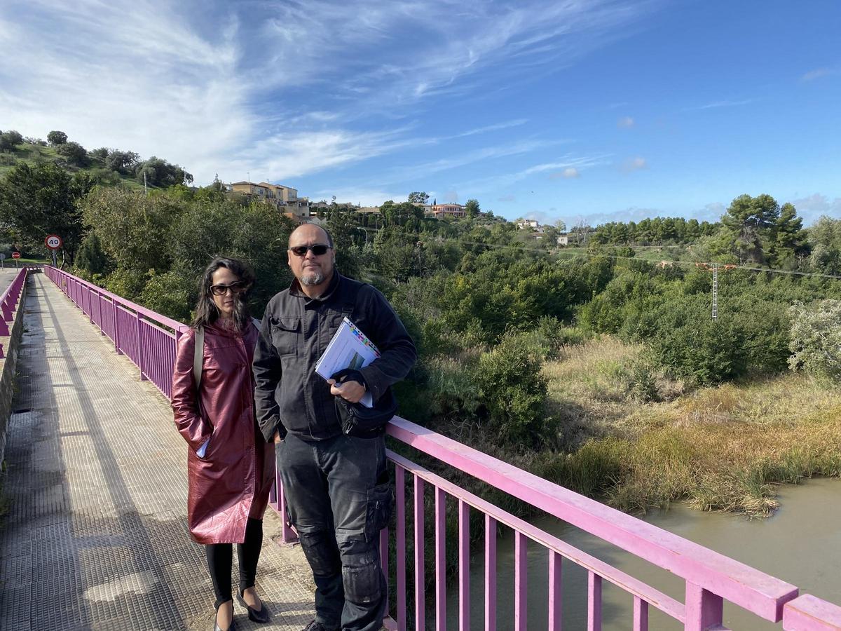 Carlos Gutiérrez y Gema López Briones, miembros de la asociación de vecinos de La Cava, en el puente que cruza hacia la parcela donde se realizará la actuación urbanística.