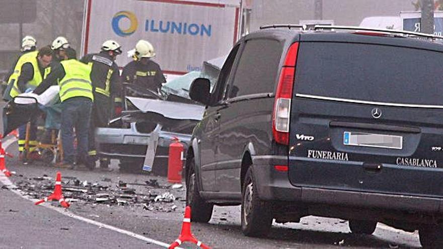 Los equipos de emergencias auxilian a la conductora, atrapada en su vehículo.