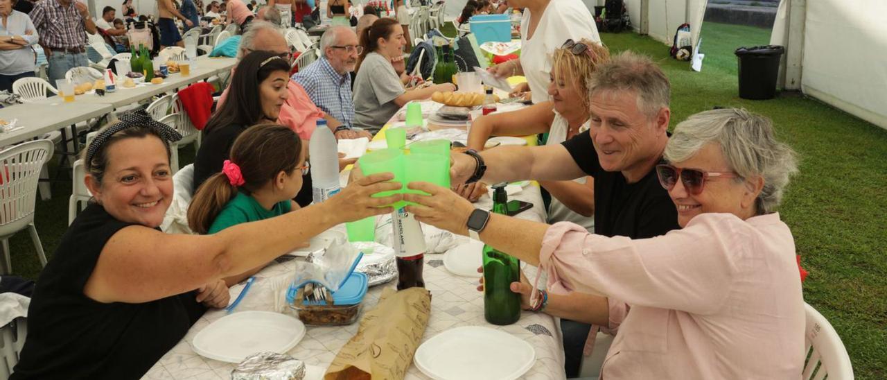 Carmen Saras brinda con sidra con José Enrique Plaza y Ana González, ayer, en la comida de socios del Club Natación Santa Olaya. | Juan Plaza