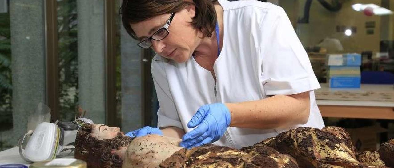 Una profesional del Museo trabaja en la restauración de una pieza. // Rafa Vázquez