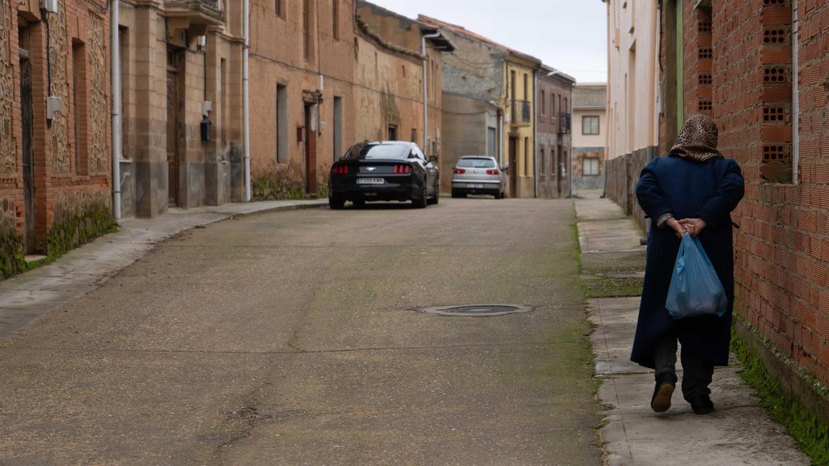 Una mujer camina por un pueblo de Zamora.