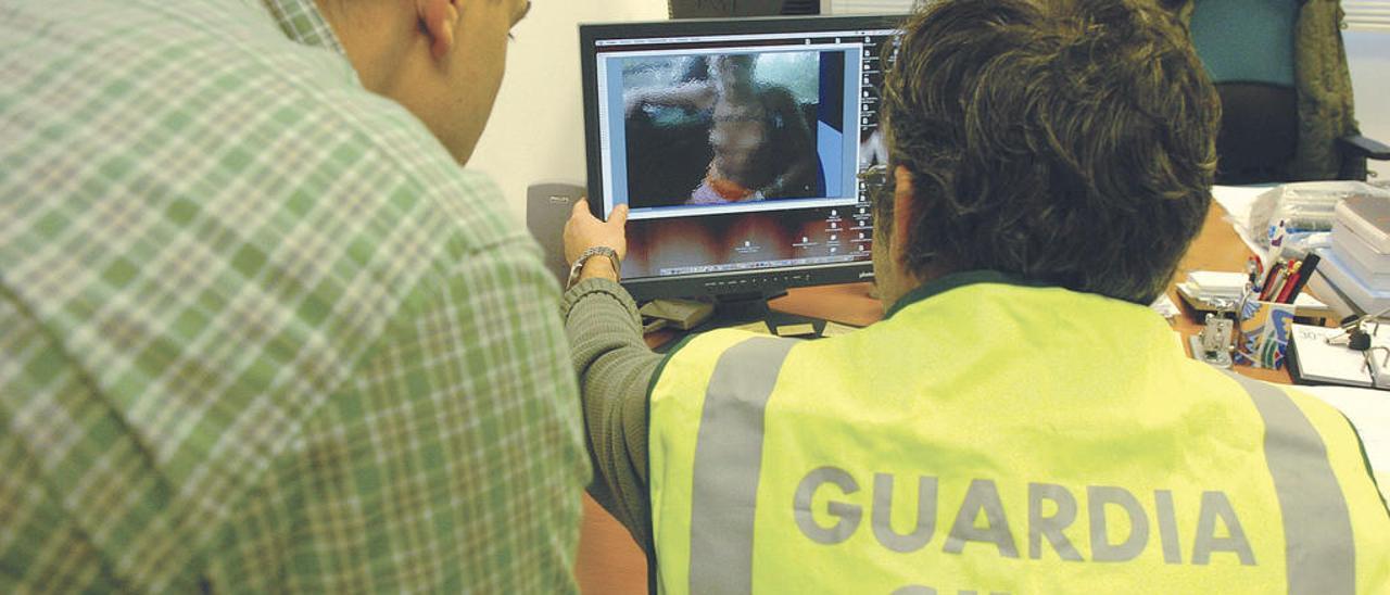 Dos expertos de la Guardia Civil en delitos informáticos durante una investigación. // Gustavo Santos