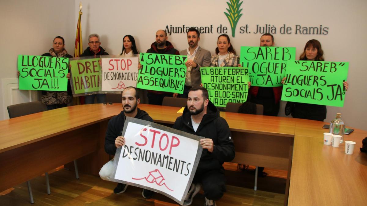 Un grup d'afectats pel desnonament previst amb l'alcalde de Sant Julià de Ramis, Marc Puigtió, i l'activista de la PAH, Marta Afuera