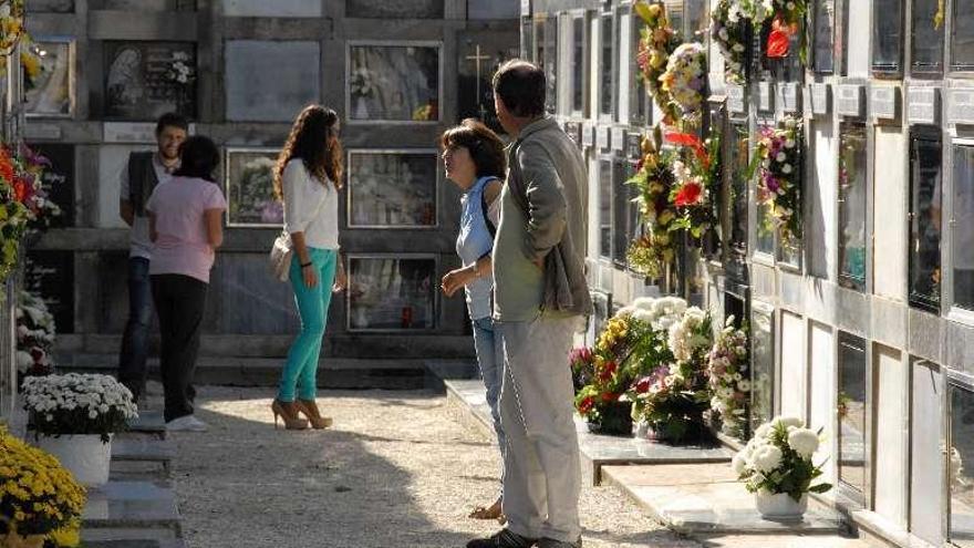 Vecinos engalanan las lápidas en el camposanto de Domaio. // G.N.