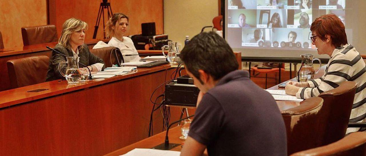 Esther Llamazares y Arancha Martínez Riola atienden a la intervención de Carmen Pérez Soberón, sentada en el Pleno junto a Manuel Campa.