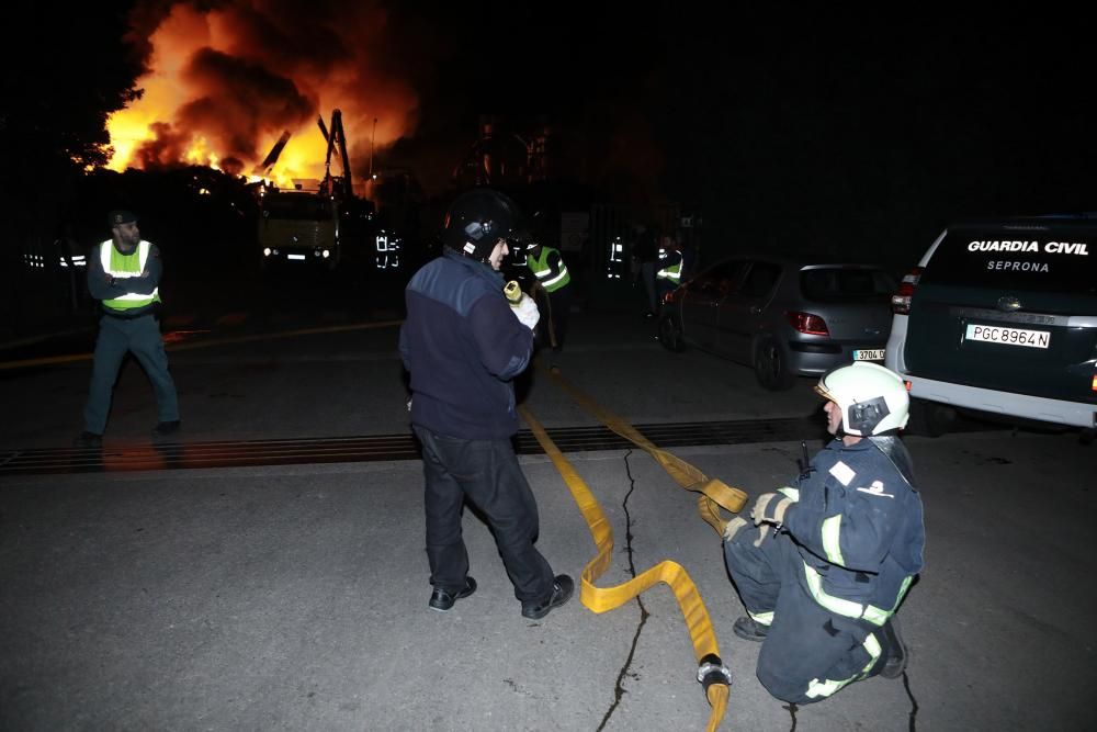 Labores de extinción del incendio de un desguace en Gijón