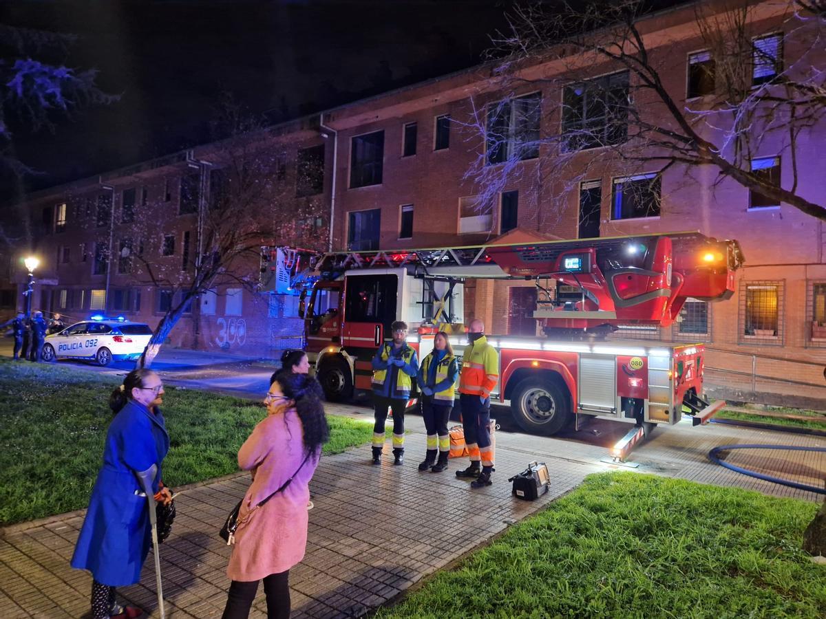 Sanitarios y desalojados junto a un camión de bomberos que intervino en las labores de extinción.