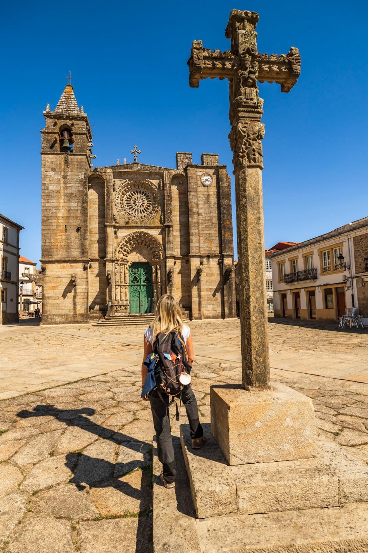Una peregrina ante la iglesia de San Martiño, en Noia, recorriendo el Camino por Muros-Noia.